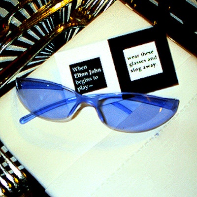 Each place setting had a pair of plastic sunglasses and a card with instructions for the guests to don them and to sing along when Elton John took the stage.