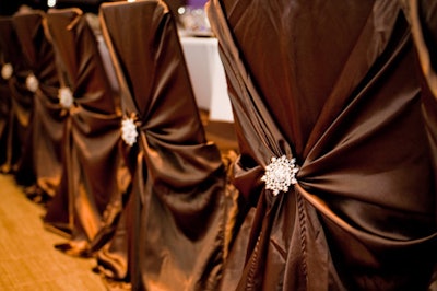 Sparkling brooches provided a focal point on the satin-wrapped chairs.