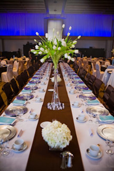 Tall vases of white tulips, surrounded by sparkling faux gemstones, served as centrepieces.