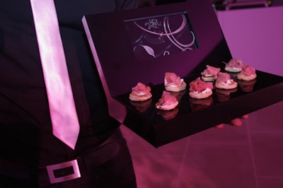 Dressed in a uniform of black and pink, waiters passed hors d'oeuvres such as pink prosciutto on fig blinis from DVD trays that displayed the same graphics as the video wall.