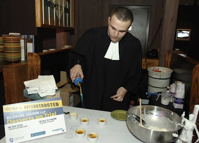 A server wearing a judicial robe caramelized crème brûlée using a blowtorch at the 'Desserts on Trial' station.