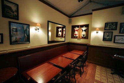 The booth resembles a French café, with furnishings and design elements like wooden and tiled flooring, dark wooden café chairs, and lamplike fixtures.