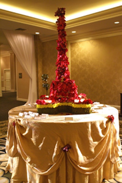 An Eiffel Tower made out of rose petals and wire served as the centerpiece of the escort card table.
