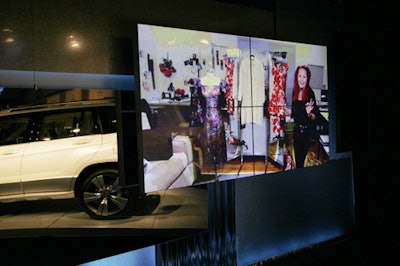 At the entrance to the tent lobby, Mercedes-Benz displays new cars next to video footage from the Sex and the City movie.