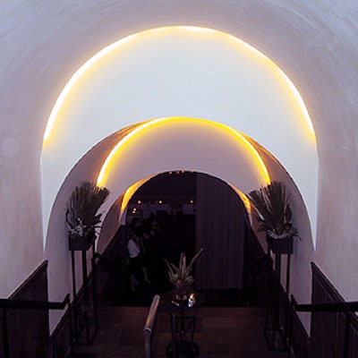 Guests descend a white arched stairway to get to Cellar Bar.