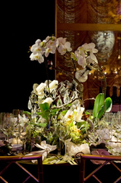 A slumped chandelier (placed as if it fell from the ceiling) intertwined with orchids, moss, and greenery on Carrier and Company's table.