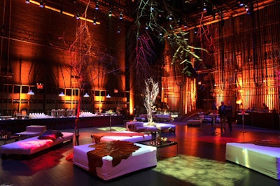 During the performance, the stage was turned into a cocktail-style space for the dessert reception, with lounge furniture, blue and orange lighting, and suspended trees lit from above in different colors.