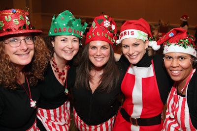 The 'Holiday Hat Factory' activity, offered by Cast of Thousands, gives groups a chance to get crafty decorating red and green hats.