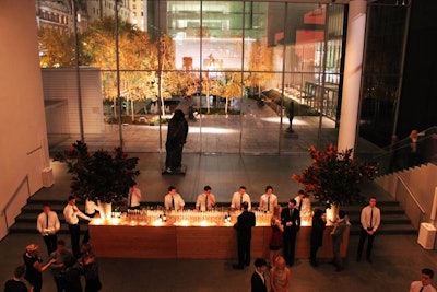 The reception area, hidden behind the entrance's hedge walls, was left mostly bare, save for a large wooden bar and two enormous floral arrangements.