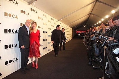 Guests arrived on a black carpet under a white tent.