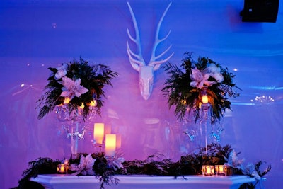Lucite chandeliers with evergreen floral pieces bordered the mantel of the fake fireplace in the bar area. A white reindeer head hung above it.