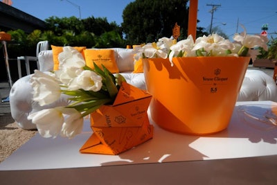 End tables displayed origami vases and ice buckets filled with flowers and champagne.