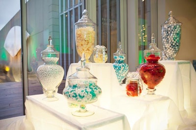 An illuminated table held jars filled with candy.