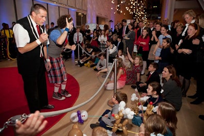 A captive young audience—many members clutching balloon animals—sat on the ground to take in the performance.