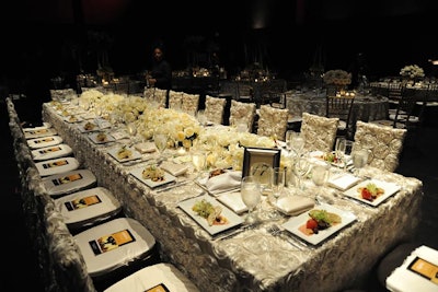Staffers set a table for Placido Domingo and gala sponsors with 20 seats dressed in all ivory.