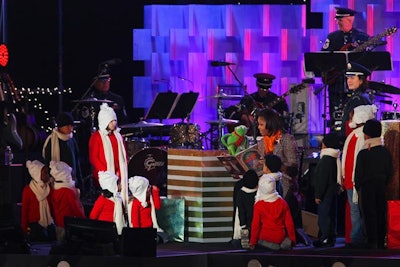 Michelle Obama and Muppet Kermit the Frog read 'Twas the Night Before Christmas to a group of children on stage during the program.