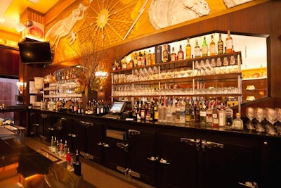 A metallic mural hangs above the main bar, which offers wine and seasonal specialty cocktails.