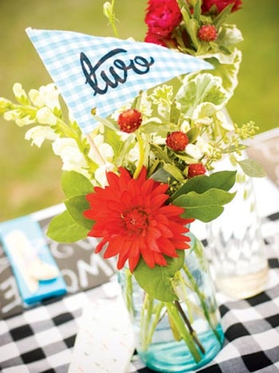 At a casual outdoor wedding in California planned by Kate Miller Events, gingham flags displaying table numbers were tucked into vintage soda bottles filled with flowers.