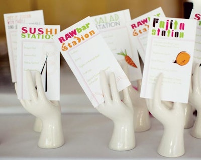 Menu cards held by ceramic hands at an event designed by Canvas & Canopy