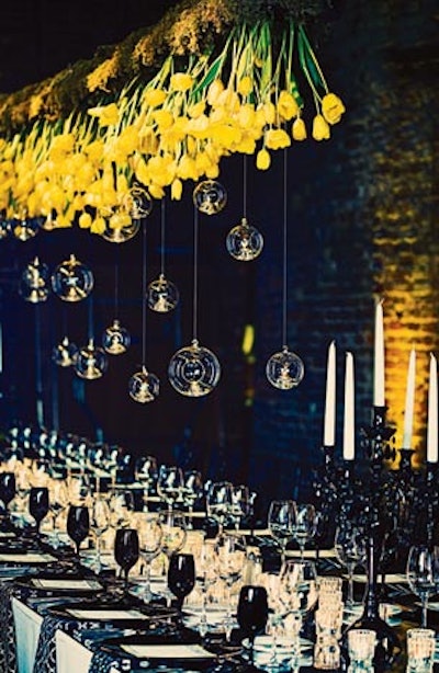 For a wedding at the King Plow Event Gallery in Atlanta, Bold American Events & Catering designed an upside-down centerpiece of yellow tulips and glass globes that hung above the head table.