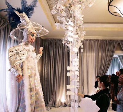 A cirque performer helped guests reach escort cards suspended from the ceiling at a wedding designed by Gloria Wong Design and Jubilee Lau Events.