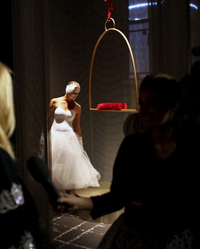 Showcasing a white gown, another dancer made swan-like poses on and around a bird cage-like perch.