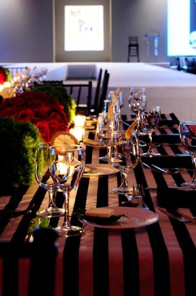 Red roses greenery on the tables offset the black-and-white-stripped linens.