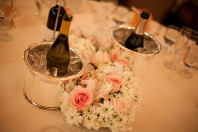 Floral centerpieces wove between silver wine buckets on tabletops.