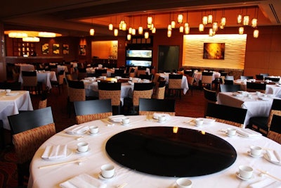 Fine dining Chinese restaurant Genting Palace is dressed in warm hues and both circular and small square tables.