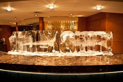 An ice sculpture with the event's logo stood on top of a bar.