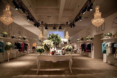 Much like the rest of the event space, the interior of the boutique was decorated with hand-painted illustrations, lush arrangements of white roses, and white furnishings.