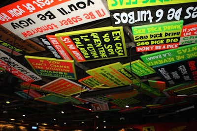 Brightly painted signs, most with sayings related to drinking, decorate much of the ceiling.