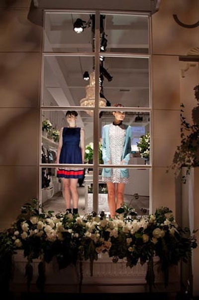Instead of mannequins, live models posed in the store's windows, adding a more animated element to the display. Window boxes made from reclaimed wood held white roses and hydrangeas.