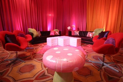 Syzygy created two lounge groupings with chairs, sofas, pillows, and mushroom ottomans in the same colors as the drape.