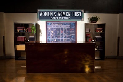 Much of the decor referenced ideas and sketches from the series, including a bar designed as a nod to the 'Women & Women First Bookstore.' Designed to look like a check-out counter with shelves of feminist literature, the setting also included a chalkboard calendar and oscillating desk fan.