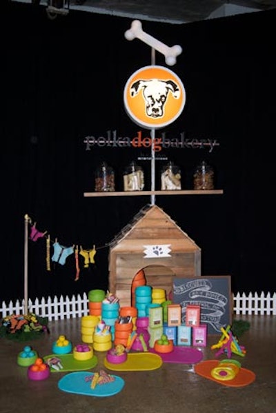 Bright and colorful dog products are the hallmark of the Polka Dog Bakery, a Boston-based purveyor of gourmet dog treats and gear, so the area for the boutique included a dog house, dog accessories, and a mini white picket fence.