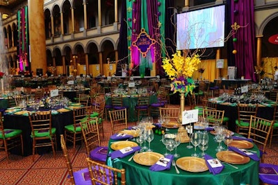Tabletop floral arrangements incorporated feathers in Mardi Gras colors.