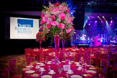 The other tabletop centerpieces comprised pink roses and hydrangeas in high vases. The tables sparkled with hot pink tinsel linens and matching bows for the chairs, provided by Over the Top.