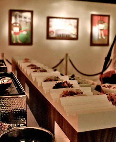 At the Tuesday-night reception, caterer Pinch Food Design supplied a decidedly savory menu of nibbles. The production team worked with the company to include its interactive stations, including one for miniature tacos (pictured) in the space without detracting from the overall design.