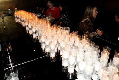 Hundreds of glass votive candles filled the space, adding to the intimate atmosphere of the event.
