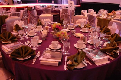 Green and purple jewel-toned linens added more color to the space, and a stack of books covered with the Book Lover's Ball logo served as each table's centrepiece.