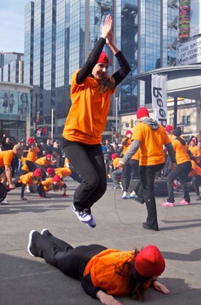 The group was dressed in orange and black and performed exercises in Dundas Square.