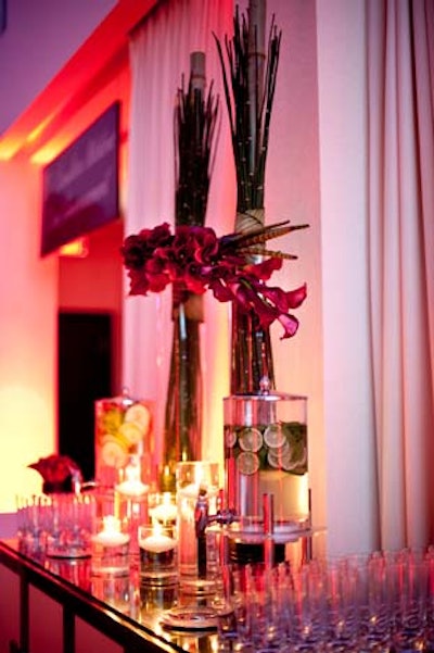 Jackie O created a tall flower arrangement with orchids and bamboo at a refreshments table. Guests helped themselves to flavoured water.