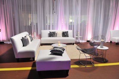 The cocktail reception took place inside the Mercedes-Benz dealership's service bay. All-white lounge furniture and white draping decorated the space.