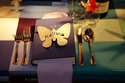Playing off the mobile of paper butterflies hanging above David Stark's literary-themed Benjamin Moore table, guests' names were laser cut onto book pages cut into the shape of butterflies.
