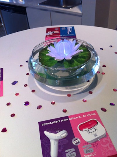 Glowing centerpieces on highboy tables looked like futuristic water lilies. Pink and purple jewels and product collateral also decorated tabletops.