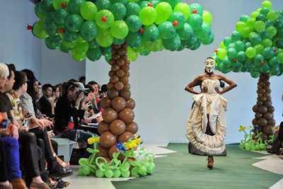 Designer Adrian Wu filled the Studio at World MasterCard Fashion Week with playful balloon trees. Models walked the runway—a path of green Astroturf—wearing theatrical dresses and masks from the movie V for Vendetta.