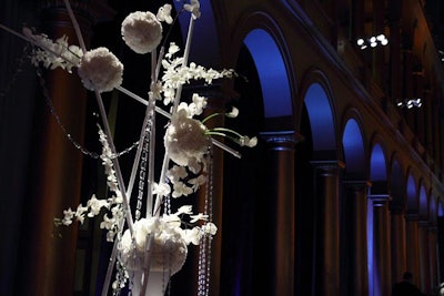Tutera designed three centerpieces, the tallest of which had balls of white hydrangeas attached to painted white bamboo stalks decorated with suspended crystals.