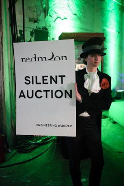 A performer held a sign that alerted guests to the silent auction.
