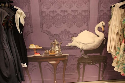 A mural on the wall, which appears three-dimensional from far away, depicts a swan and a traditional English tea service set against a violet backdrop.